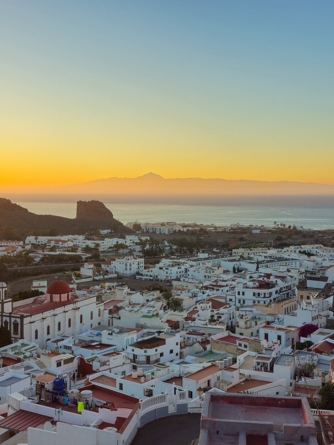 Agaete: vistas desde arriba del pueblo costero con el atardecer de fondo.